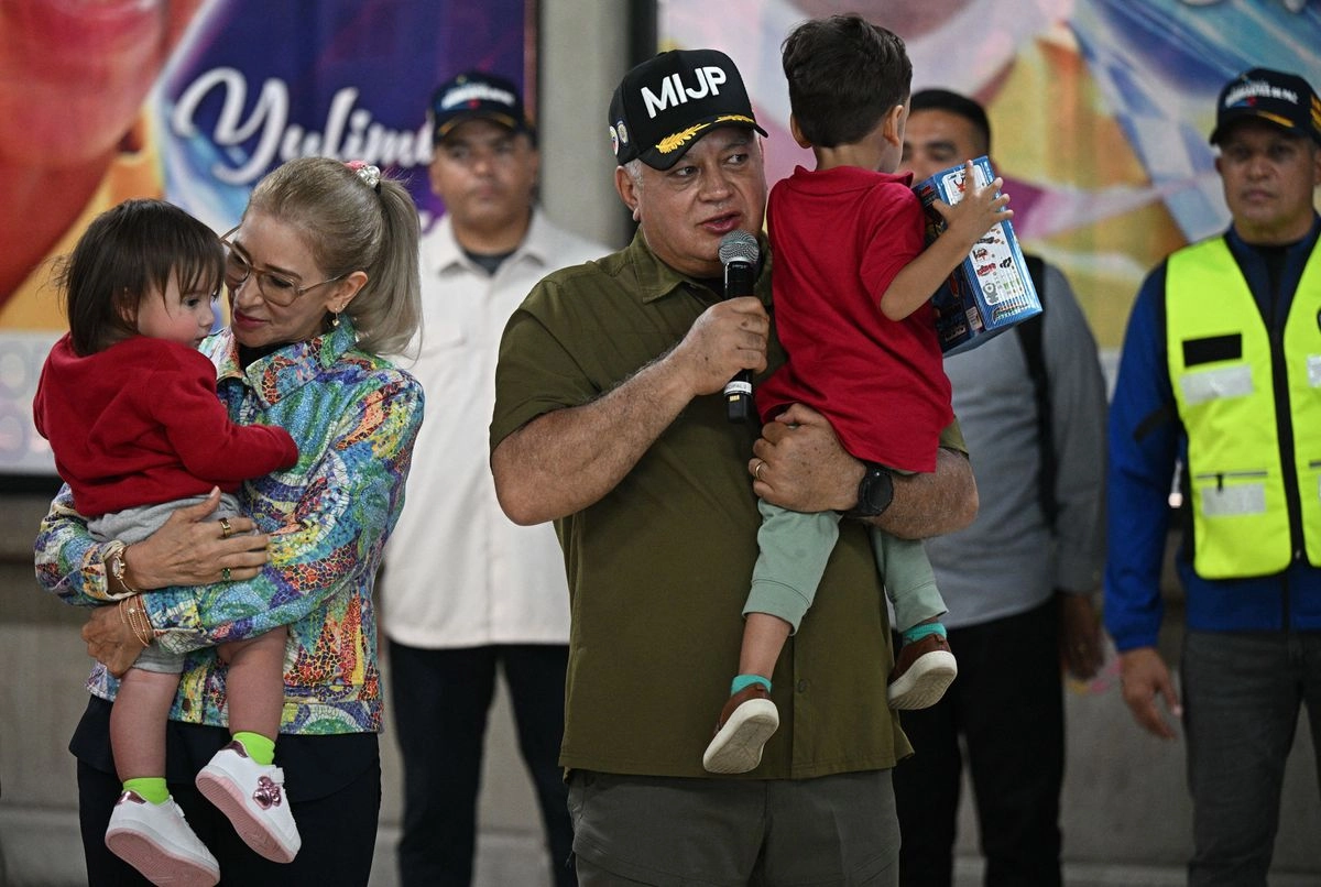 El ministro del Interior de Venezuela, Diosdado Cabello, carga a uno de los menores deportados desde EU tras su llegada al Aeropuerto Internacional Simón Bolívar de Maiquetía, el 18 de julio de 2025. Foto
