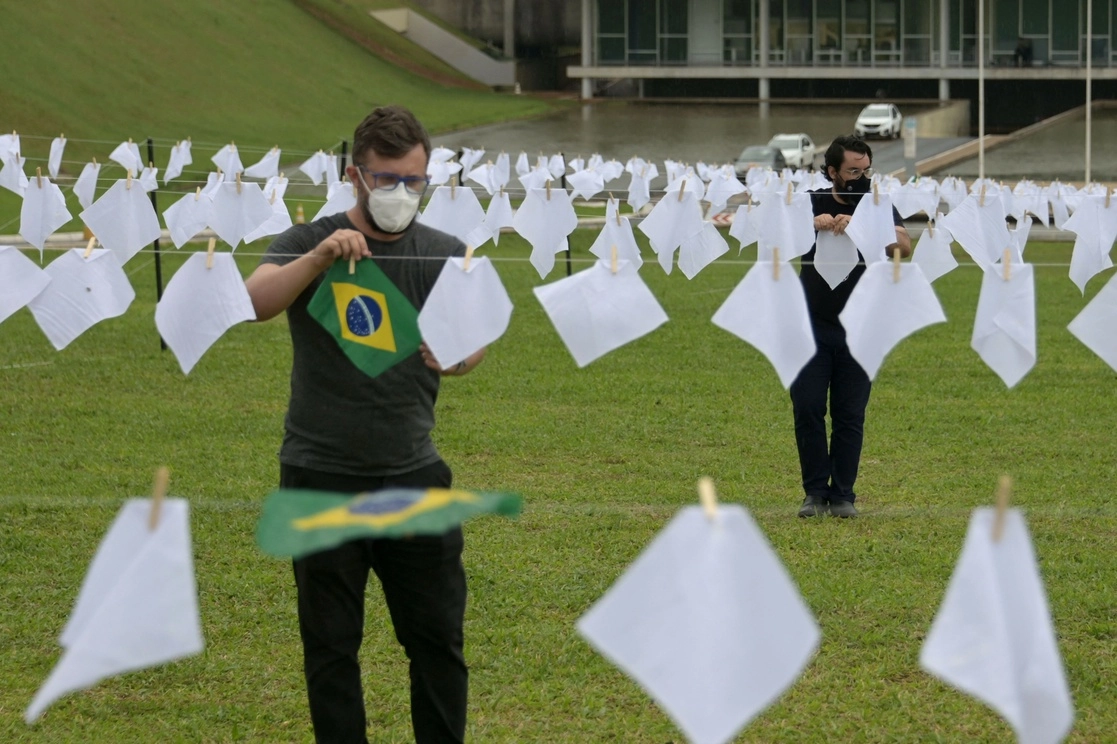 Activistas colocan pañuelos blancos frente al Congreso de Brasil, en memoria de los fallecidos por Covid-19. Foto Afp