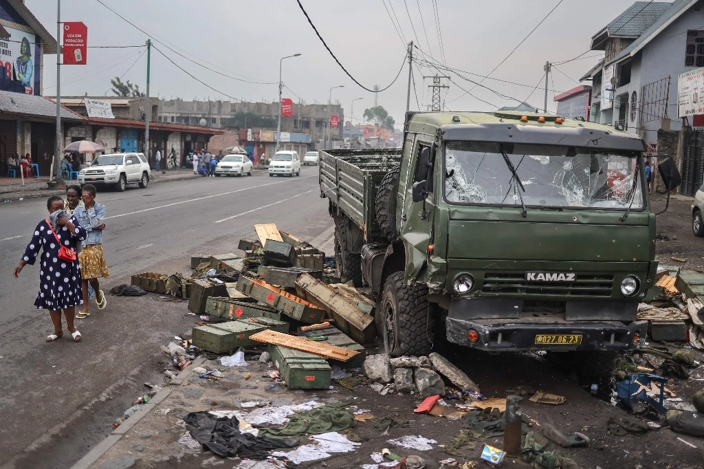 Los residentes se cubren el rostro mientras pasan junto a un camión militar acribillado a balazos en Goma el 31 de enero de 2025. El grupo armado M23, respaldado por Ruanda, se desplazó hacia el sur mientras se acercaba a un aeropuerto militar clave en la República Democrática del Congo el 31 de enero de 2025, un día después de prometer tomar la capital Kinshasa y mientras aumentaban las críticas internacionales. Foto Afp