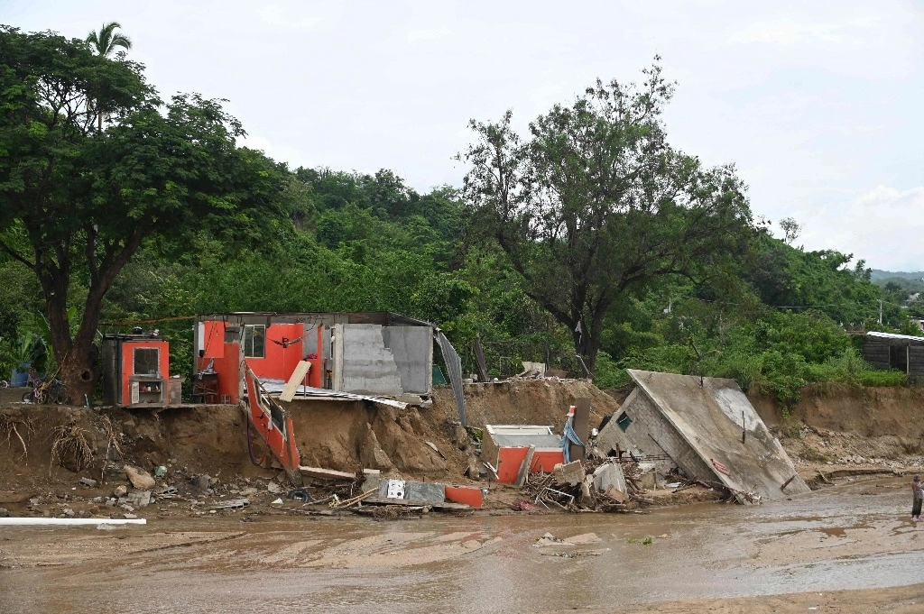 Casas que se derrumbaron debido a la corriente del arroyo que se elevó con las fuertes lluvias tras el paso del huracán John en Acapulco, Guerrero. Foto Afp