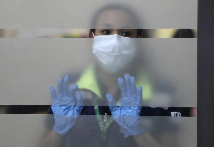 Una trabajadora del Aeropuerto Internacional de la Ciudad de México usa un tapabocas para evitar la transmisión del coronavirus Covid-19. Foto Yazmín Ortega Cortés
