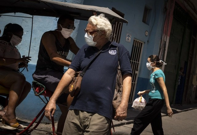 Personas caminan en calles de la Vieja Habana usando cubrebocas, como medida sanitaria ante el Covid-19. Foto Ap