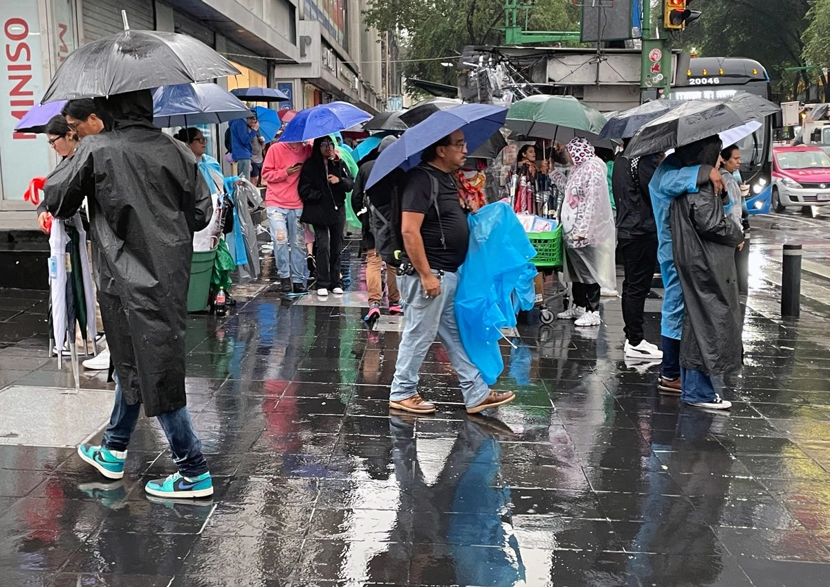 Personas se cubren de la lluvia en la zona centro de la CDMX. Foto