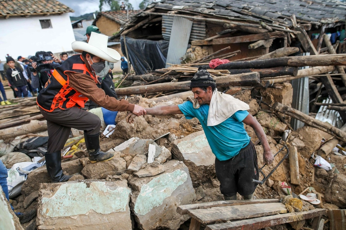 El presidente peruano, Pedro Castillo (izq.) ayuda a un hombre en una casa destruida por un terremoto en el departamento de Amazonas, noreste de Perú, el 28 de noviembre de 2021. Foto Afp