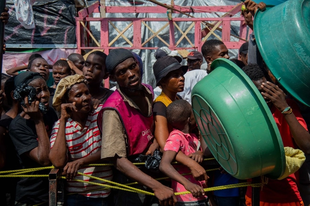 Desplazados de Haití esperan la entrega de alimentos en un campamento de Puerto Príncipe, el 30 de septiembre de 2024. Foto Afp  