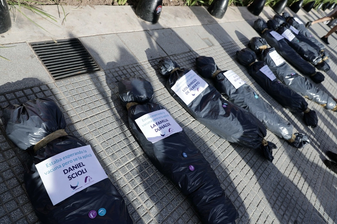 Manifestantes colgaron bolsas que simulaban contener cadáveres en las rejas del gobierno argentino. Foto Afp