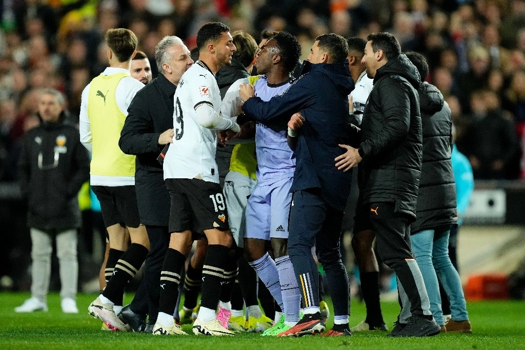 Vinicius Junior, centro, del Real Madrid, está restringido mientras discute con Selim Amallah del Valencia al final del partido de fútbol de La Liga entre Valencia y Real Madrid en el Estadio Mestalla de Valencia, España, el 2 de marzo de 2024. Foto Ap