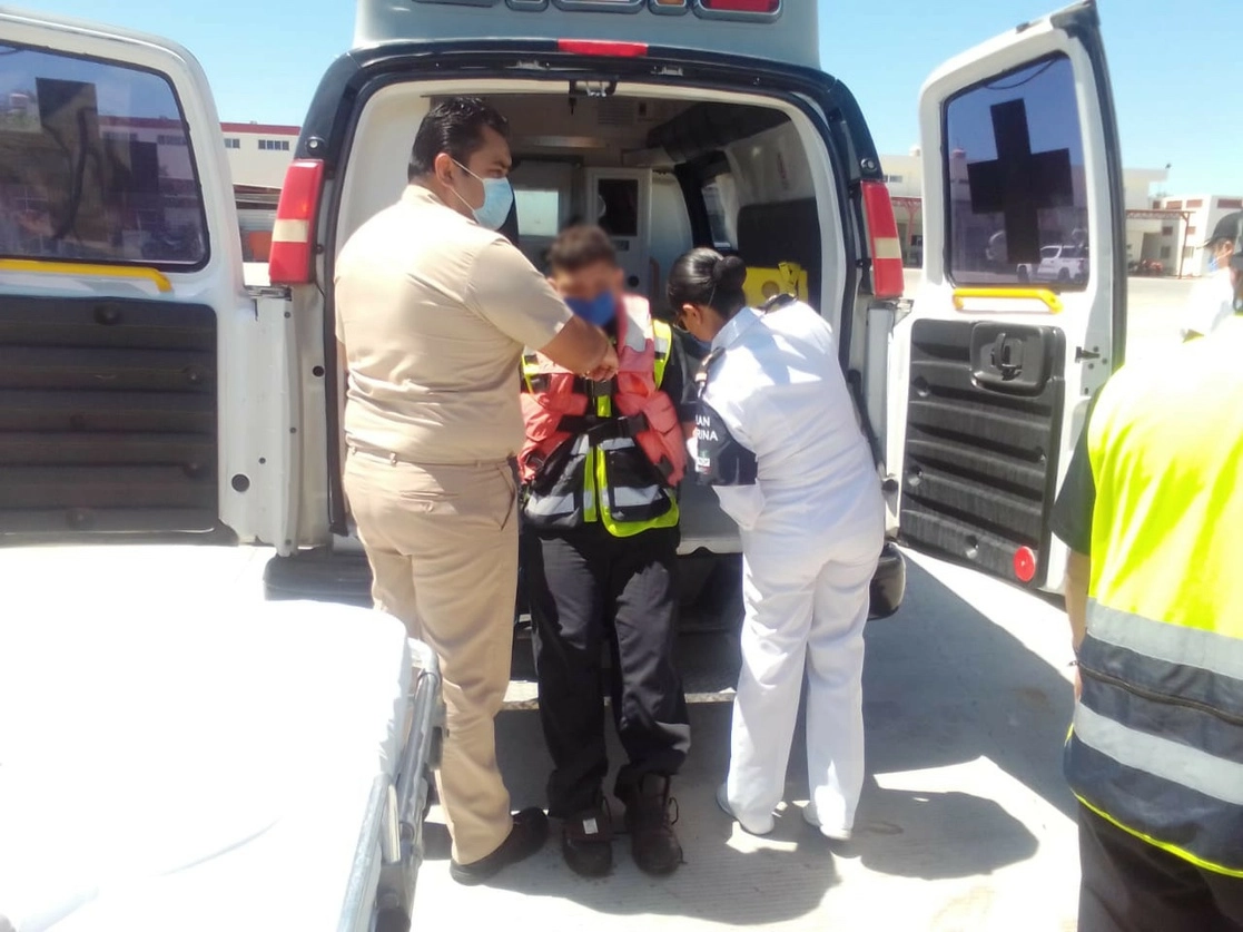 Personal de la Marina apoya a uno de los tripulantes de la embarcación. Foto Semar