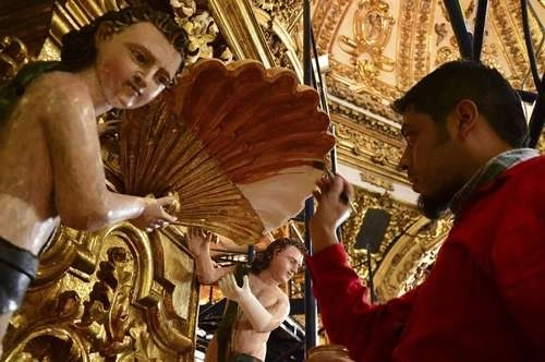 Un trabajador del INAH restaura un retablo en un templo de Tlaxcala. Foto Cuartoscuro.com