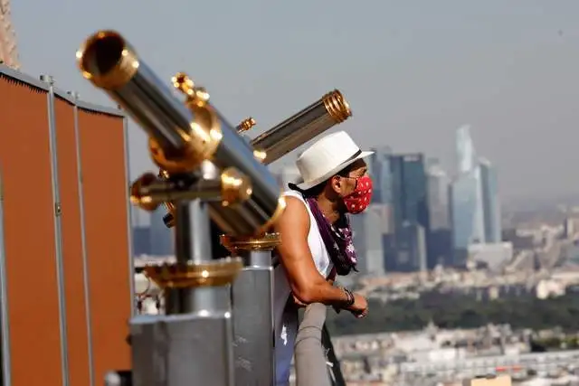 Un hombre observa París desde una de las plataformas de la Torre Eiffel, que volvió a abrir hoy. Foto Afp 