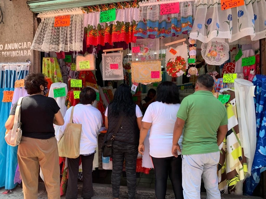Un grupo de personas espera su turno para ser atendidos por el dependiente de un local de venta de telas en una calle del Centro Histórico de la Ciudad de México, el 20 de septiembre de 2021. Foto María Luisa Severiano 