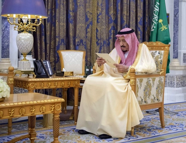 El rey Salmán de Arabia Saudita lee un documento mientras recibe a dos de sus embajadores en el palacio de Riad. Foto Ap