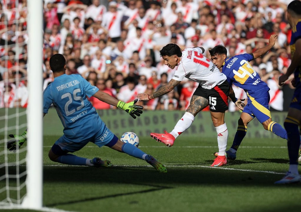 Sebastián Driussi (c), de River Plate, disputa el balón con el guardameta Agustí­n Marchesín (i), de Boca Juniors, durante el partido correspondiente a la Jornada 15 del Torneo Apertura de la Liga Profesional celebrado en el Estadio Antonio Vespucio Liberti, en la ciudad de Buenos Aires, capital de Argentina, el 27 de abril de 2025.