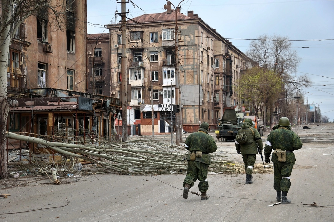 Militares de la milicia de la República Popular de Donetsk pasan junto a edificios de apartamentos dañados cerca de la planta metalúrgica Illich Iron & Steel Works, en un área controlada por las fuerzas separatistas respaldadas por Rusia en Mariúpol, Ucrania. Foto Ap