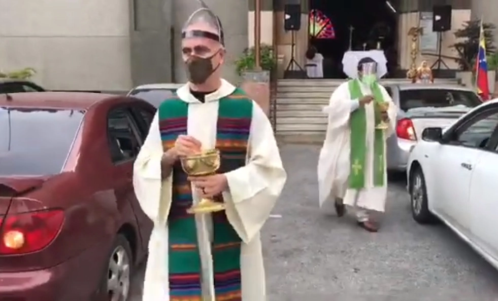 Bajo medidas de bioseguridad los religiosos realizan la ceremonia y se acercan sólo a los carros para entregar en la mano la hostia a los feligreses durante el acto de la comunión. Imagen tomada de la cuenta de Youtube de la Arquidiócesis de Caracas