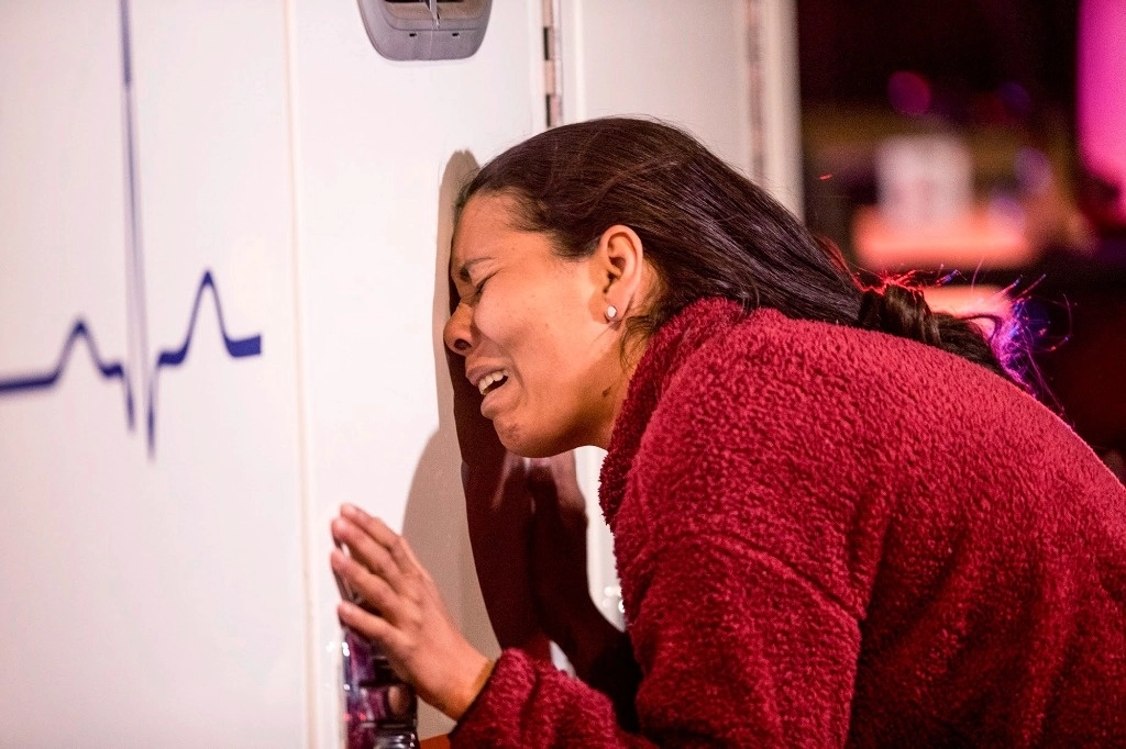 Una migrante llora en la ambulancia que atiende a uno de sus seres queridos, tras el incendio en el albergue de Ciudad Juárez, el 28 de marzo de 2023. Foto ‘El Paso Times’ vía Ap