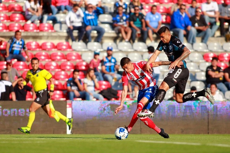 Luis Reyes (izquierda) del San Luis y Enrique Triverio del Querétaro disputan el balón durante el juego. Foto Jam Media