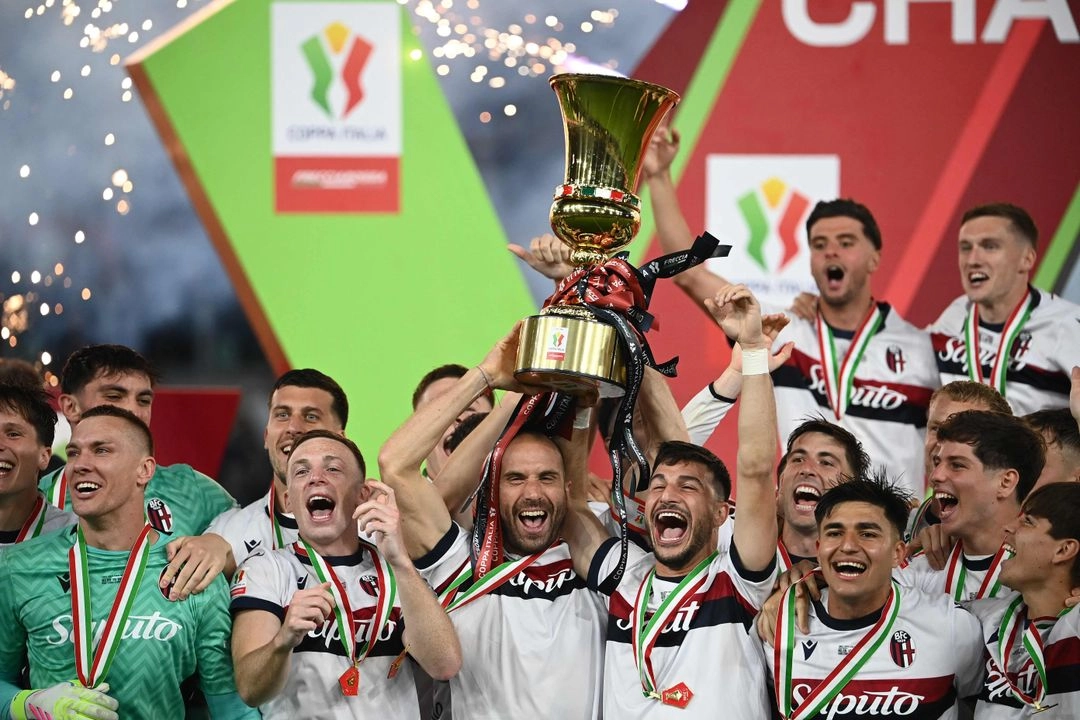 El defensa italiano #29 del Bolonia, Lorenzo Desilvestri, y el delantero italiano #07 del Bolonia, Riccardo Orsolini, sostienen el trofeo para celebrar después de ganar la final de la Copa de Italia (Coppa Italia) entre el AC Milan y el Bolonia en el estadio Olímpico de Roma, el 14 de mayo de 2025. Foto