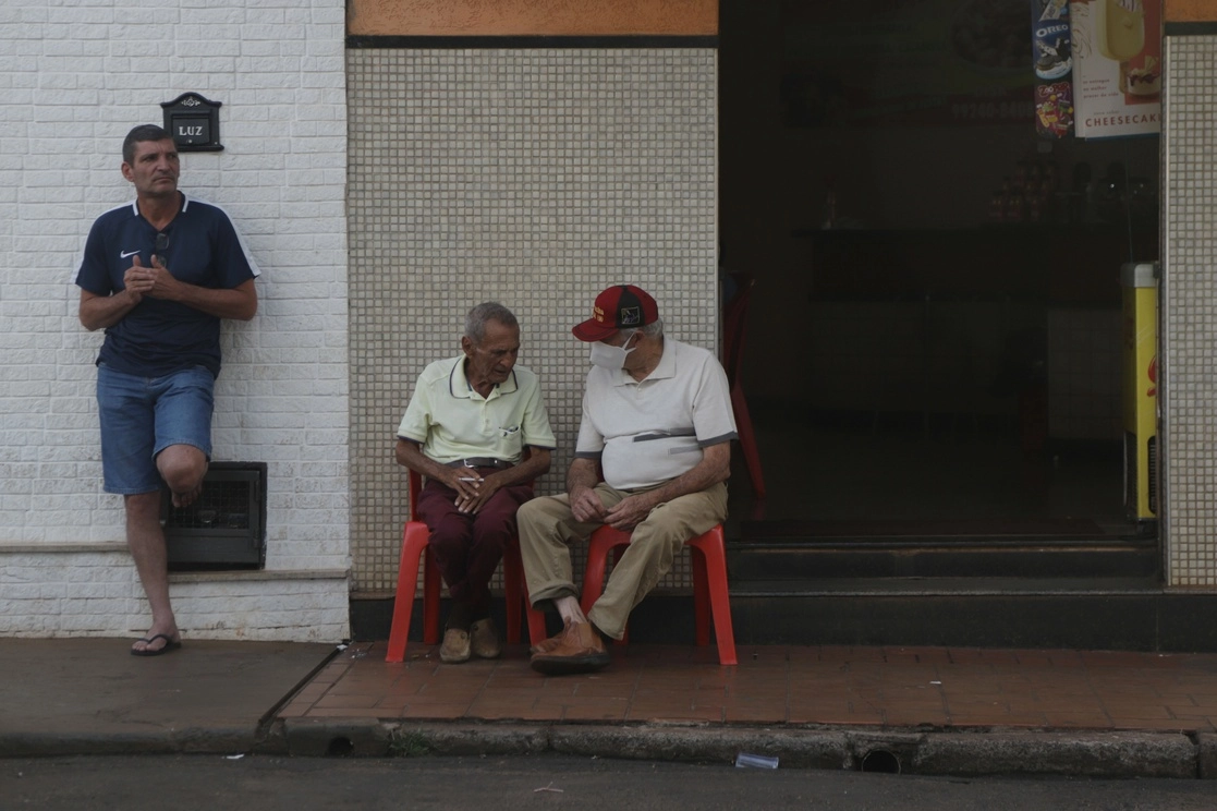 Dos  hombres conversando frente a una tienda, en el municipio de Serrana, en el estado de Sao Paulo. Foto Xinhua