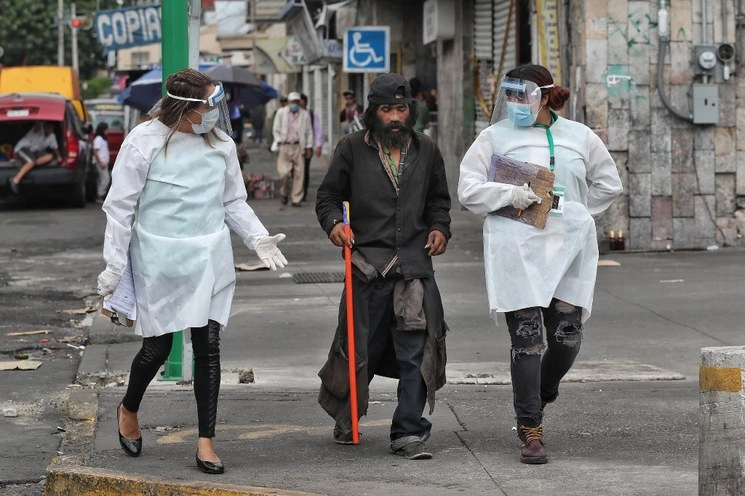 Enfermeras asignadas a la brigada de apoyo para las personas en situación de calle trasladan a una persona en situación vulnerable a un hospital en la Ciudad de México, ante la emergencia sanitaria por Covid-19, el 23 de abril de 2020. Foto Marco Peláez