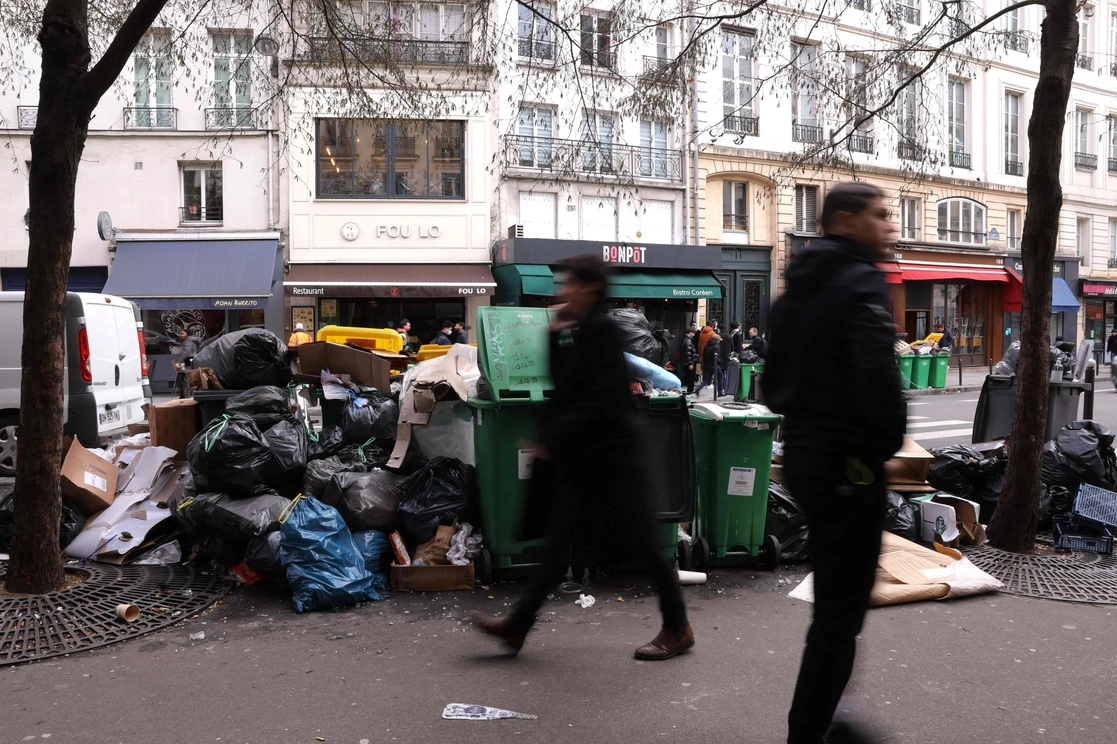 Contenedores de basura doméstica en una calle de París que se ha cumulado desde que los recolectores de basura se declararon en huelga contra la reforma de pensiones propuesta por el gobierno francés. Foto Afp