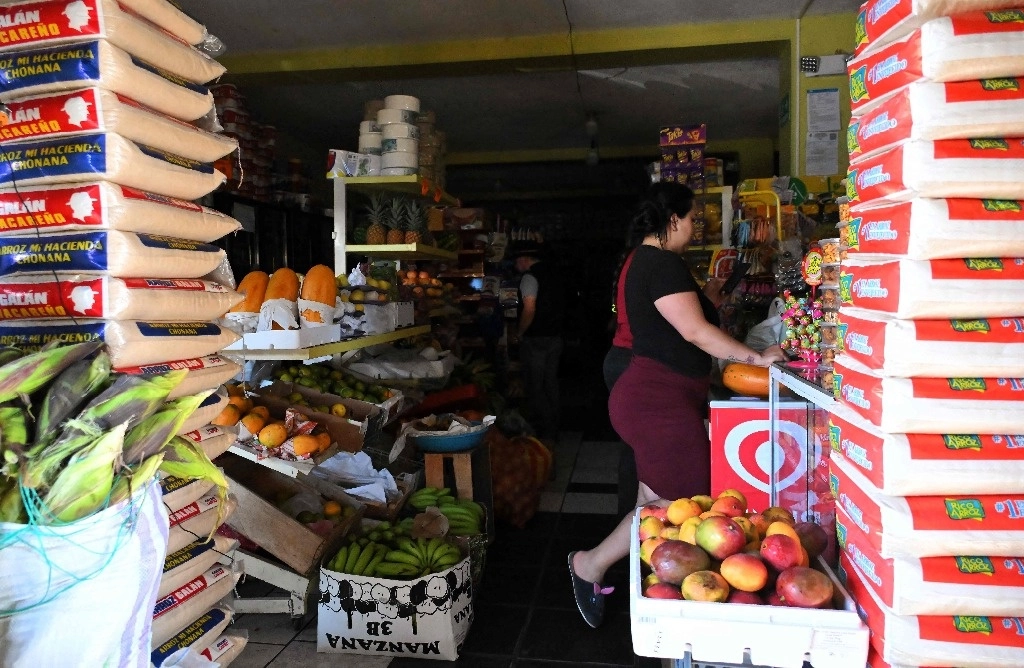 Una mujer compra alimentos en una tienda sin electricidad en Quito el 25 de octubre de 2024. Foto Afp