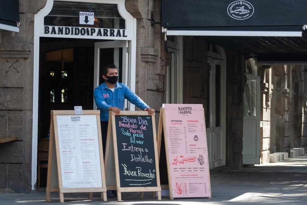 Un mesero a la entrada de un restaurante ubicado en la esquina de Álvaro Obregón y Orizaba, en la colonia Roma, Ciudad de México. Foto Pablo Ramos / Archivo