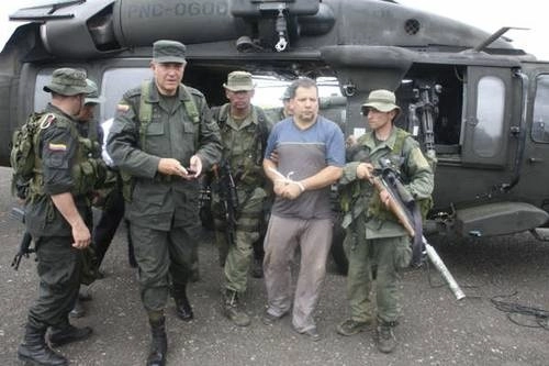 En imagen de archivo, policías custodian al narcotraficante y ex jefe del Clan del Golfo, Daniel Rendón Herrera, "Don Mario", tras su captura en Antioquia, Colombia. Foto Reuters