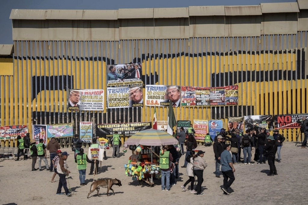 Ayer domingo, a horas de la segunda llegada de Donald Trump a la presidencia de EU, un grupo de migrantes y activistas se manifestaron frente al muro fronterizo en Playas de Tijuana. Con pancartas y lonas con frases en contra de la presidencia de Trump, los protestantes exigieron a las autoridades estadounidenses que no se cancele el programa CBP One y no se realicen las deportaciones masivas. Foto Cuartoscuro 
