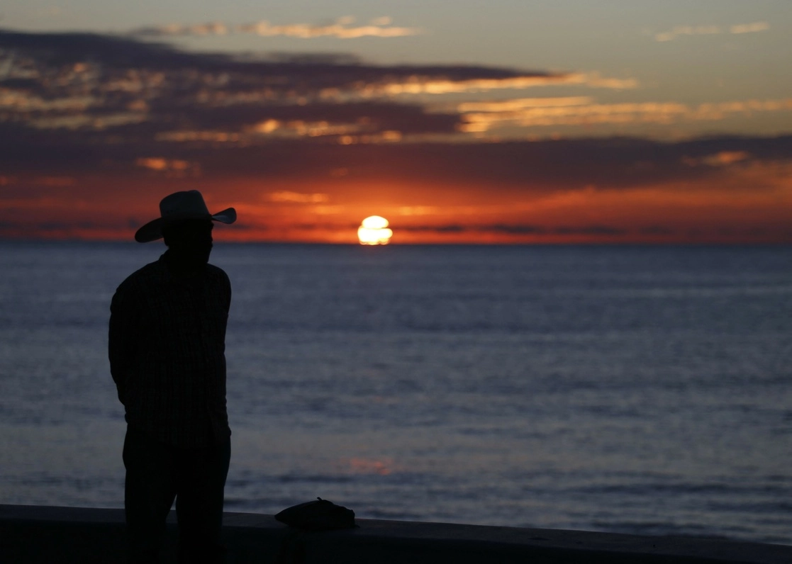 Un hombre observa la puesta de sol mientras el huracán ‘Orlene’ se aproxima a Mazatlán, Sinaloa, el 3 de octubre de 2022. Foto Afp