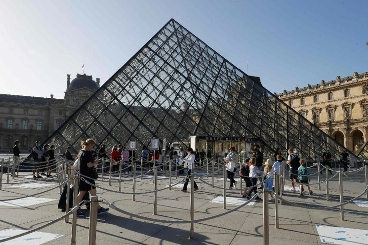 : El Museo de Louvre reabrió sus puertas el pasado 6 de julio. En la imagen visitantes se forman junto a la ‘Pirámide del Louvre’, diseñada por el arquitecto chino Ieoh Ming Pei. Foto Afp / Archivo