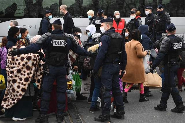 Migrantes esperan a ser evacuados por la policía francesa en un campamento al norte de París. Foto Afp