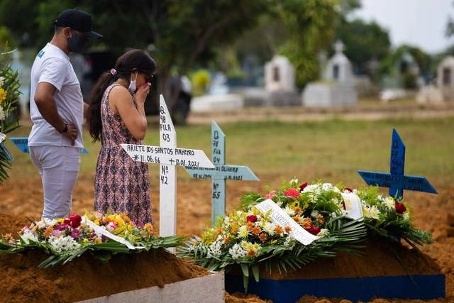 En el cementerio de ‘Nossa Senhora Aparecida’, en Manaus, Amazonia, personas asisten al funeral de su familiar, fallecido por Covid-19. Foto Afp