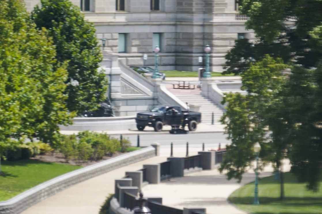 Un robot junto a una persona en una camioneta estacionada en la acera frente al edificio Thomas Jefferson de la Biblioteca del Congreso, luego de que un hombre dijera a la policía que tiene una bomba, el 19 de agosto de 2021. Foto Ap