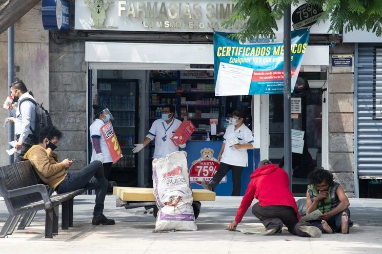 Una farmacia mantiene su actividad económica mediante la promoción de sus productos, sobre la avenida Juárez, en el Centro Histórico. Foto Pablo Ramos
