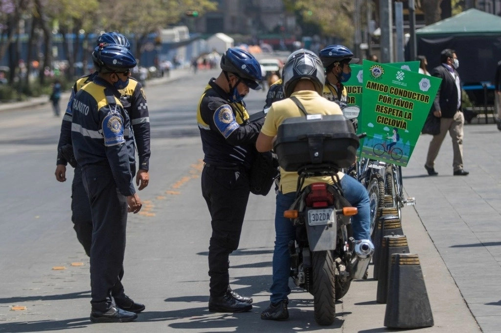 Policías sancionan a un motociclista por no respetar la ciclovía de avenida Juárez, Ciudad de México. Foto Cuartoscuro / Archivo