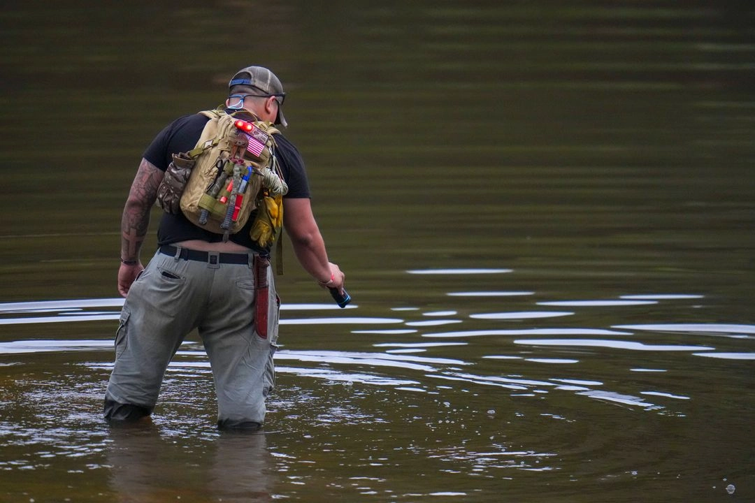 Voluntario residentede San Antonio, Texas, vadea el río Guadalupe mientras colabora en las labores de recuperación cerca de Camp Mystic, en Hunt, Texas, tras una inundación repentina que arrasó la zona, el 6 de julio de 2025. Foto 