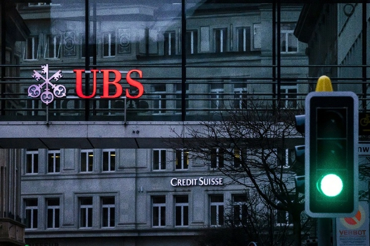 Un semáforo señala en verde frente a los logotipos de los bancos suizos Credit Suisse y UBS en Zúrich, Suiza. Foto Ap
