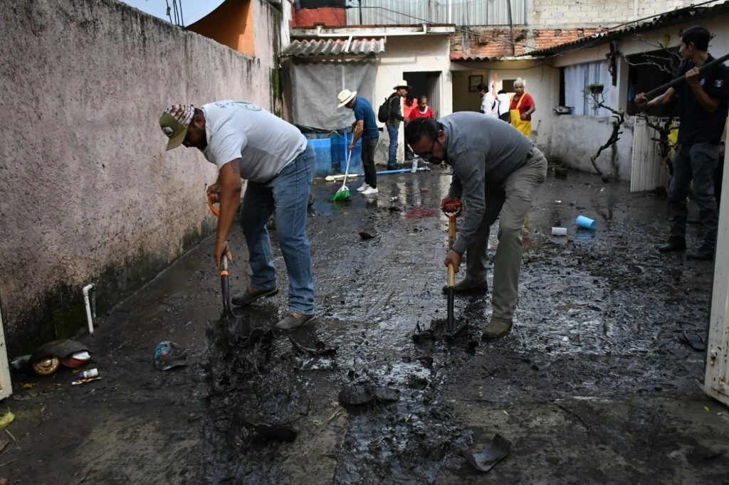 Esta mañana, personal de PC municipal ayudaba a las familias a sacar el agua, el lodo y basura que había ingresado en estas 36 casas. Foto 'La Jornada'