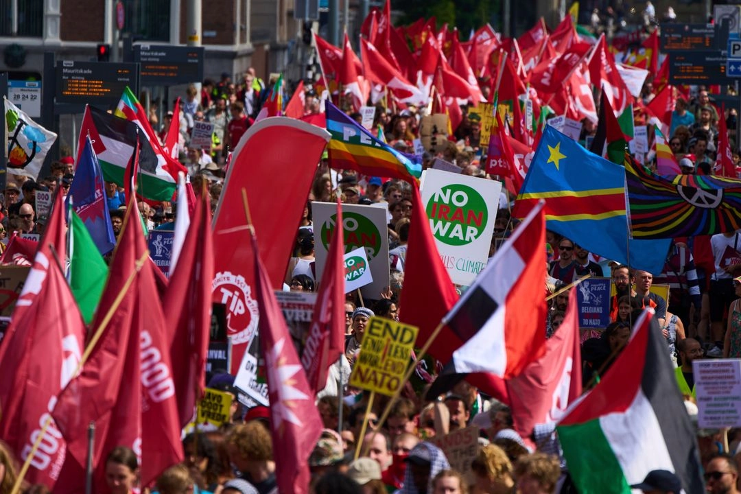 Personas portan pancartas y banderas durante una manifestación antes de la cumbre de la OTAN en La Haya, Países Bajos, el domingo 22 de junio de 2025. Foto