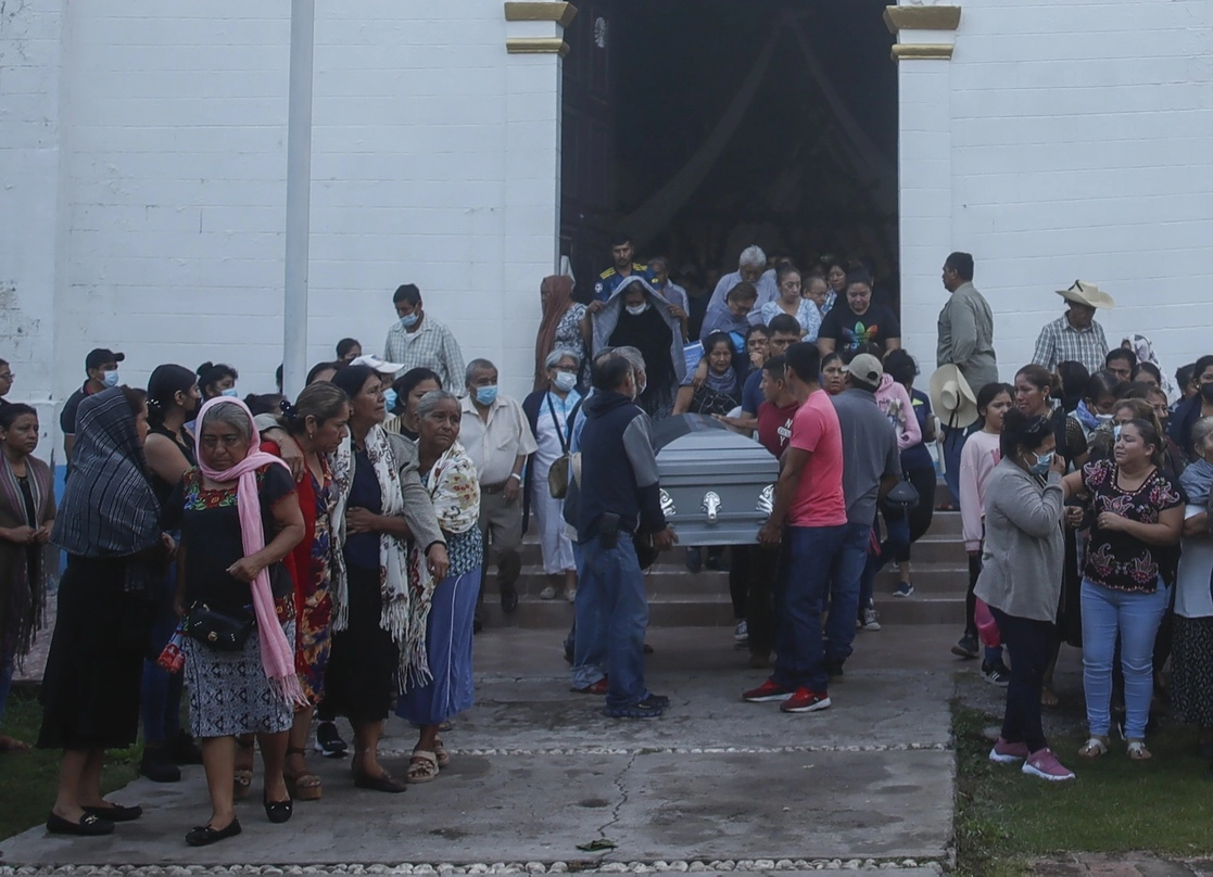 Asistentes a la misa de cuerpo presente del alcalde perredista Conrado Mendoza y de su padre, Juan Mendoza Acosta, antes de ser inhumados en el panteón de San Miguel Totolapan, en la Tierra Caliente de Guerrero. Foto Víctor Camacho