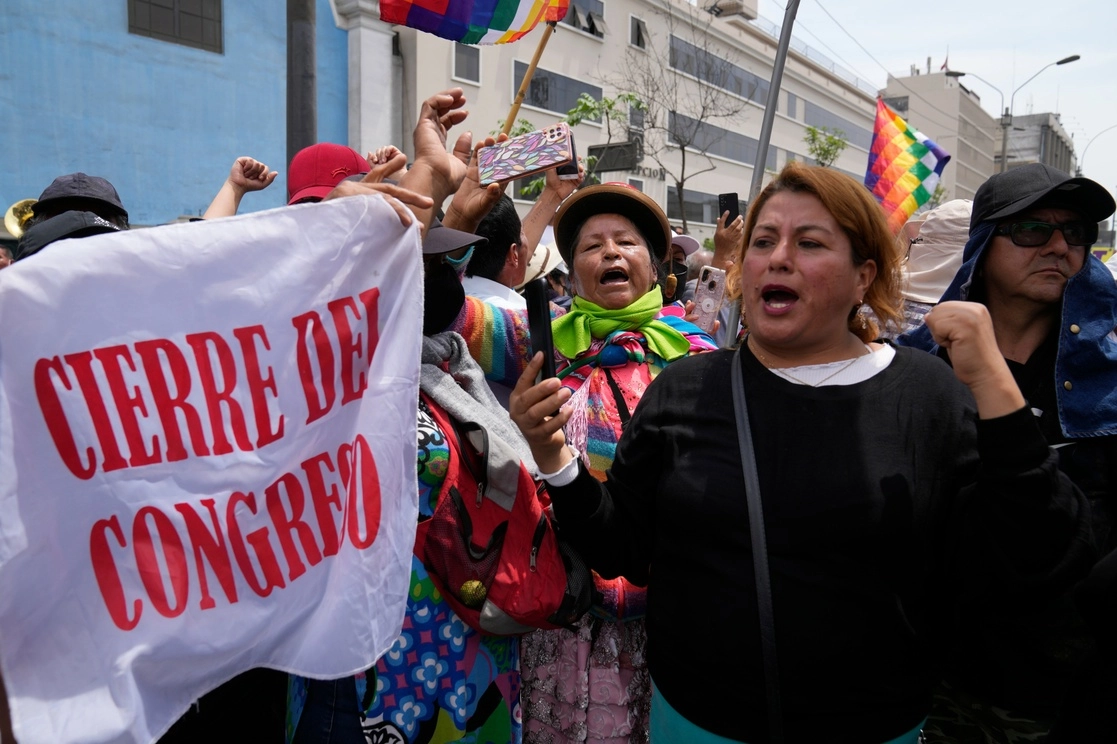 Simpatizantes del presidente peruano, Pedro Castillo, se manifiestan con una bandera que dice "Cierre del Congreso", el día de una votación de juicio político planificada contra el mandatario, cerca del Congreso en Lima, el 7 de diciembre de 2022. Foto Ap