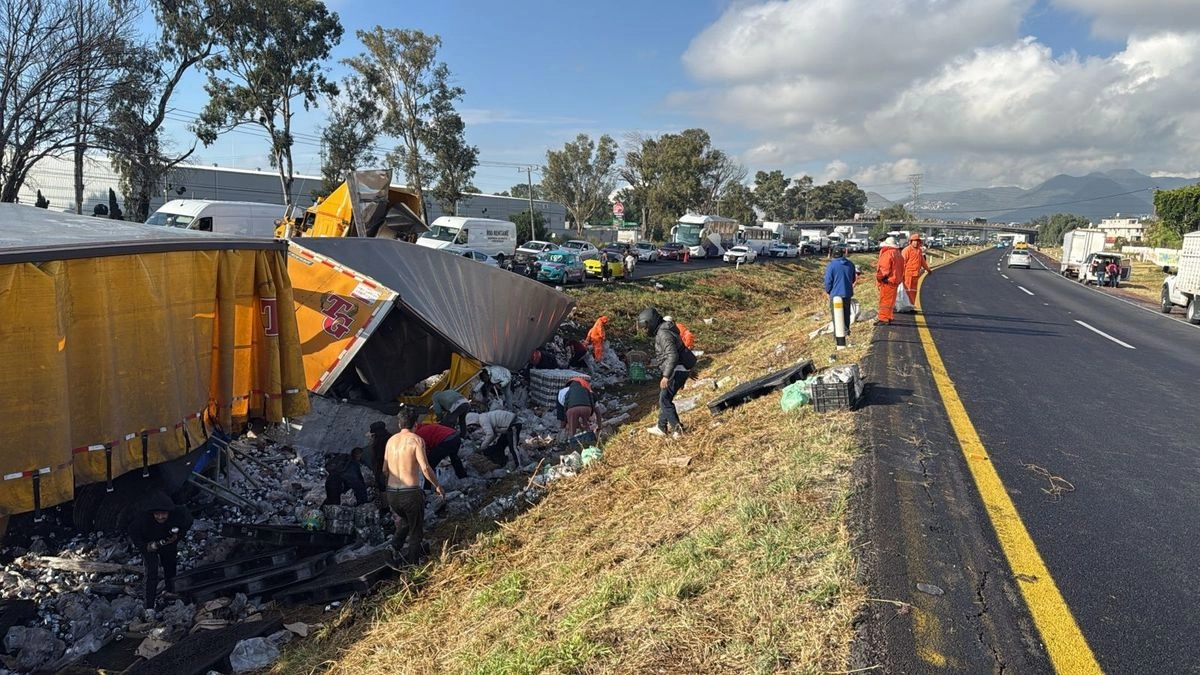 Personas roban latas de cerveza que eran transportadas en un tractocamión que volcó en la autopista México-Pirámides, a la altura del municipio mexiquense de Ecatepec. Foto 