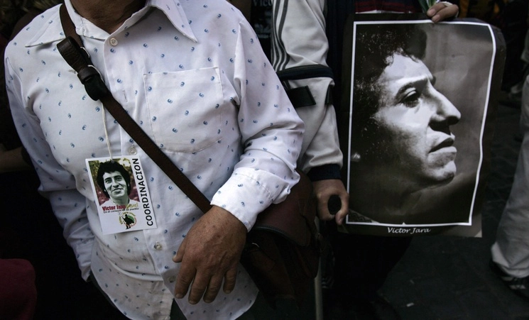 Carteles con las fotografías de víctimas de la dictadura, como el cantante y profesor de la Universidad Técnica del Estado, Víctor Jara, durante una protesta en el Cementerio General de Santiago. Foto Afp / Archivo