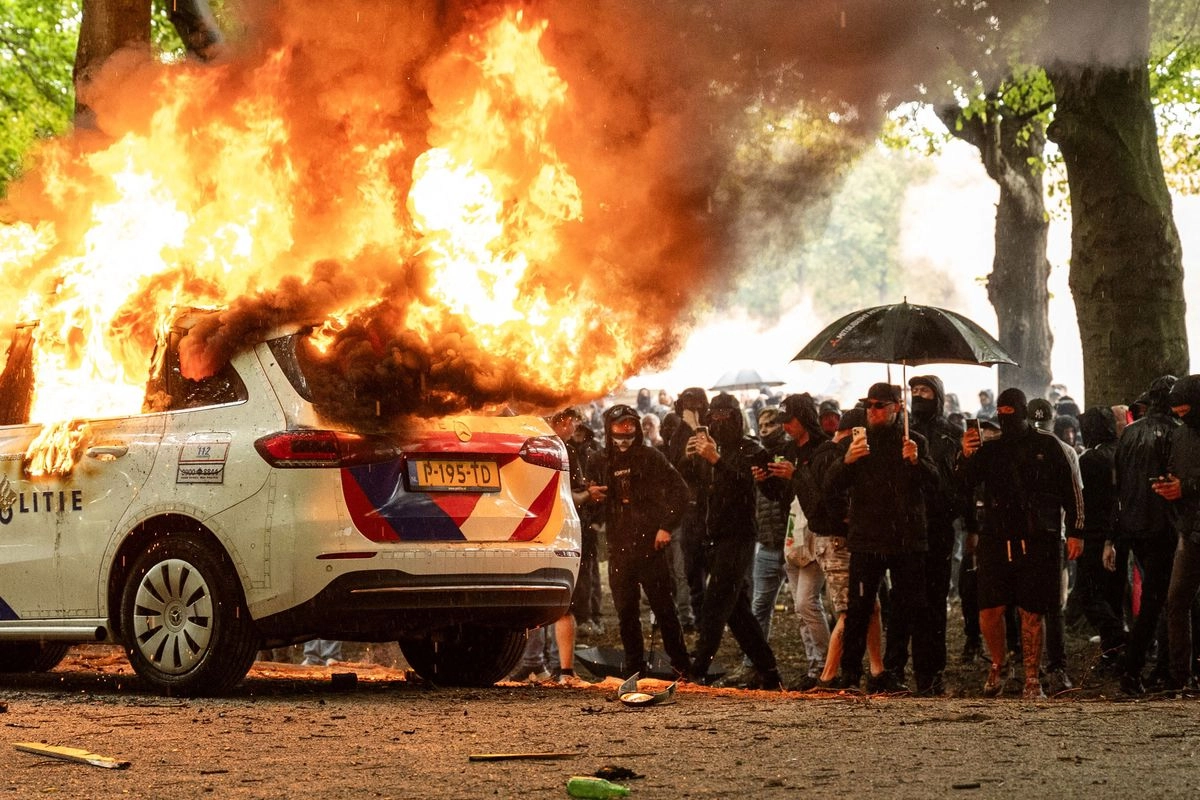 Un coche de policía es incendiado durante la manifestación "Defiende a los Países Bajos" contra la política actual del gobierno neerlandés sobre solicitantes de asilo, en La Haya, el 20 de septiembre de 2025. 