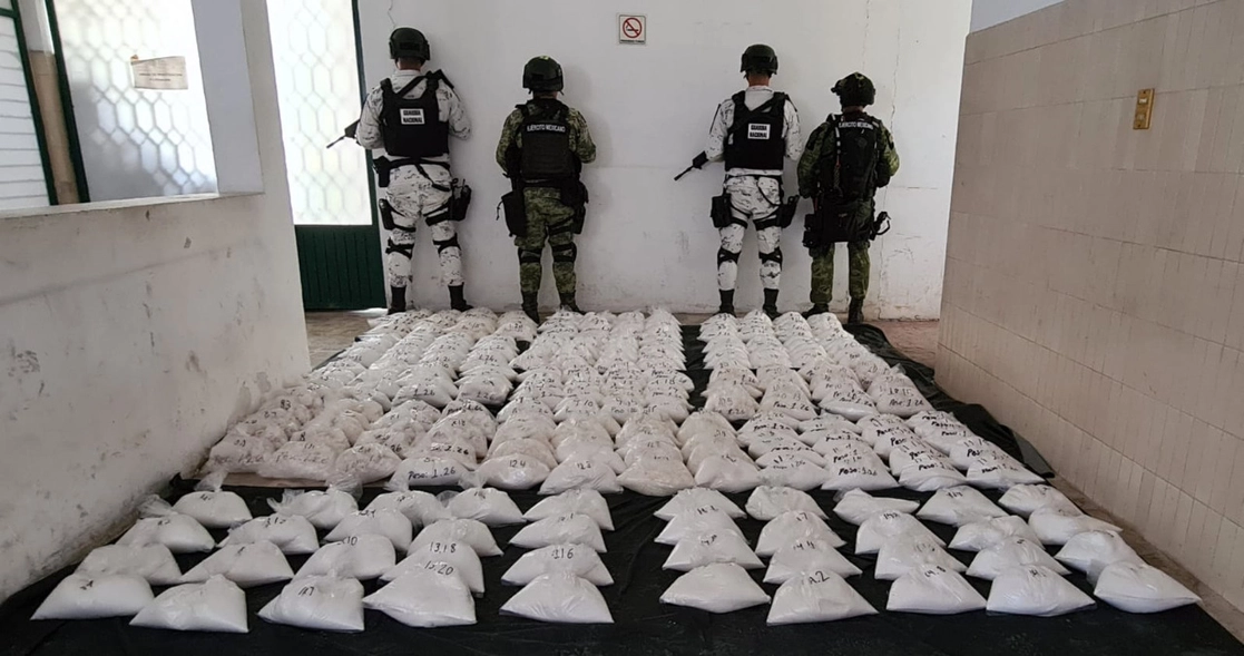 Elementos del ejército resguardan los 280 kilogramos de ‘cristal’ decomisados en la carretera Apatzingán-Buenavista, en Michoacán. Foto Sedena