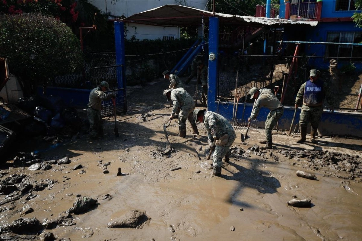 Elementos de la Marina ayudan a los habitantes de la colonia Lázaro Cárdenas con la remoción de agua, lodo y pertenencias arrastradas por el agua, tras el desbordamiento del río debido a las intensas lluvias en Poza Rica, Veracruz, el 16 de octubre pasado. 