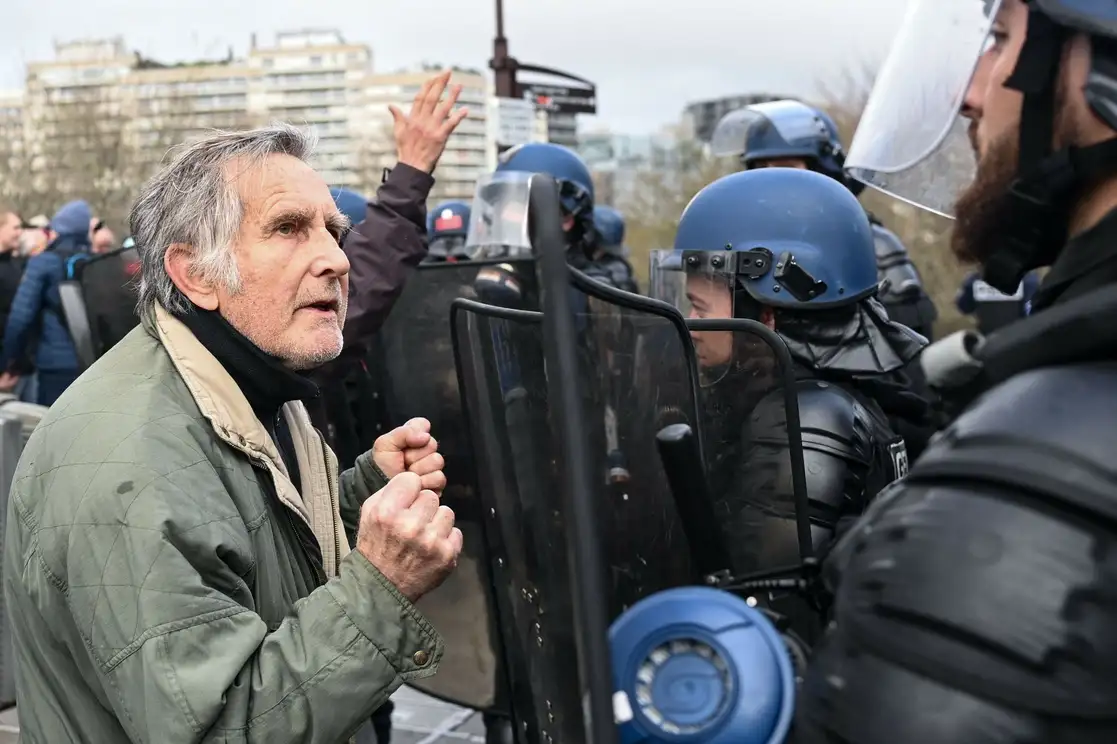 Un anciano protesta frente a policías de Francia contra la reforma de pensiones. Foto Afp