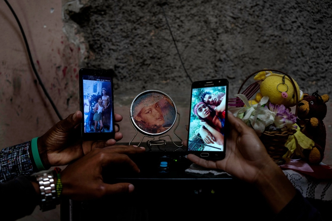 Familiares muestran fotos de tres hermanos que permanecen detenidos tras su participación en las protestas de julio de 2021 en Cuba. Foto Ap