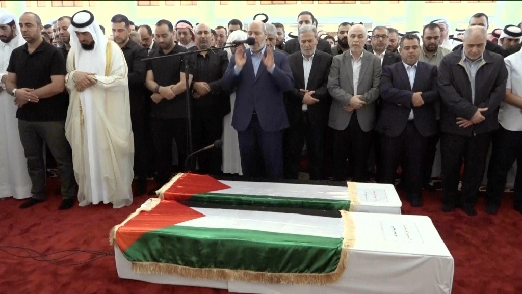 El alto mando de Hamas, Khalil al Hayya (centro), ora frente al ataúd del líder islamita palestino, Ismail Haniyeh, y su guardaespaldas en Doha, Qatar. Foto Qatar Tv vía Afp